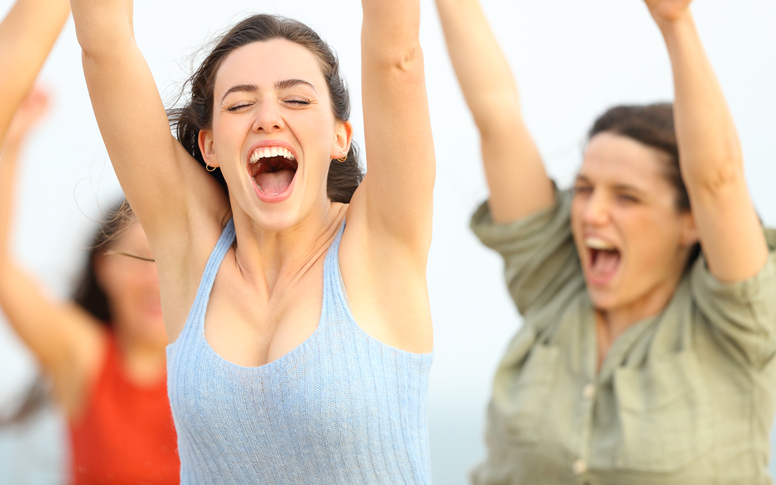 Givash girls with their arms raised in the air triumphantly